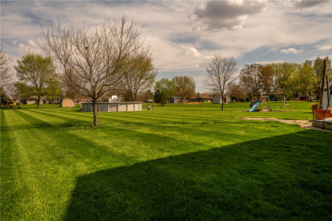 3628 Petre Road Springfield, OH 45502 - Photo 45 of 52 Expansive green lawn perfect for outdoor activities, featuring an above ground pool and swing set.