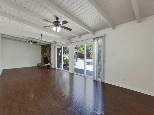 a view of an empty room with a fireplace and a window
