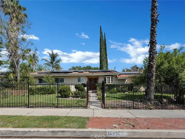 a view of an empty room with wooden floor a fireplace and a window