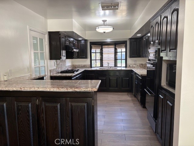 10918 Reseda Boulevard Porter Ranch, CA 91326 - Photo 7 of 19 a kitchen with granite countertop a sink and a refrigerator
