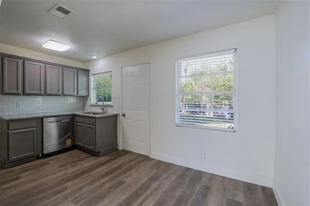a kitchen with granite countertop wooden floors and white stainless steel appliances
