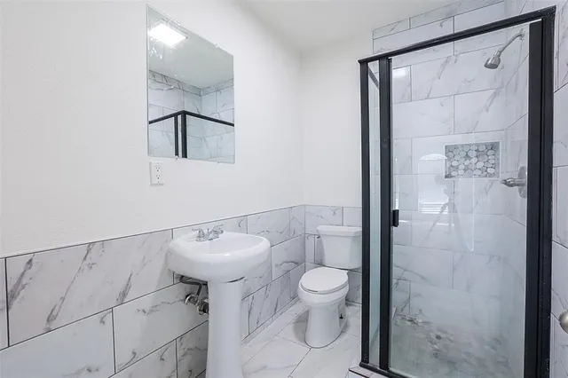 a bathroom with a toilet sink and shower