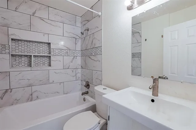 a bathroom with a sink mirror bathtub and toilet