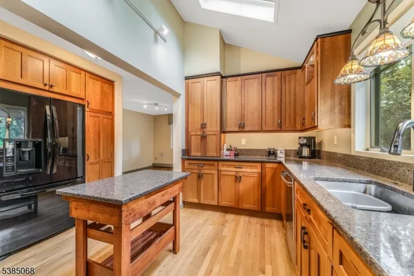 a kitchen with stainless steel appliances granite countertop wooden cabinets a sink and a stove
