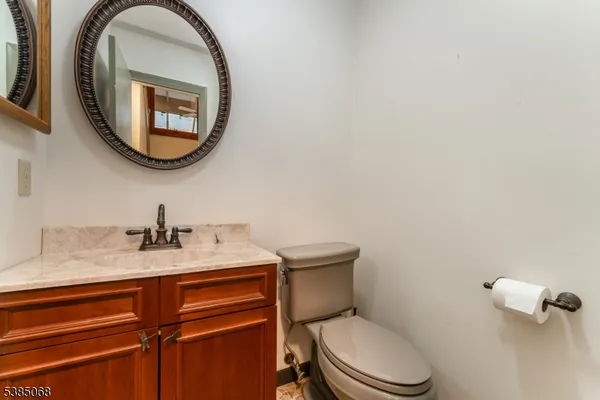 a bathroom with a granite countertop toilet sink and mirror