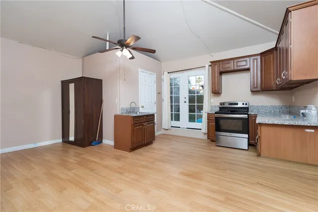 a kitchen with granite countertop a refrigerator and a stove top oven