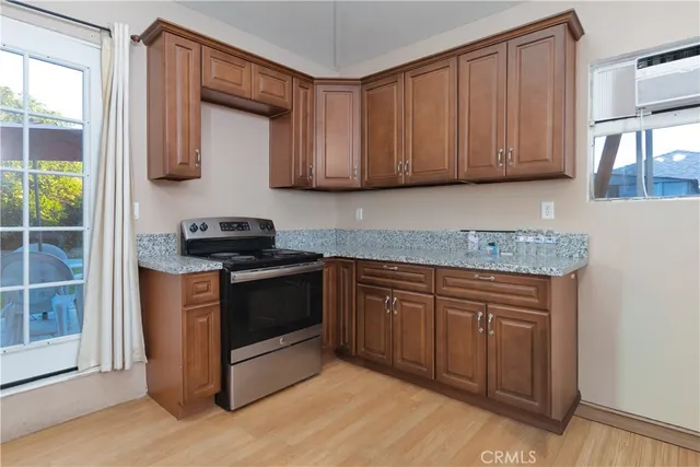 a kitchen with stainless steel appliances granite countertop a stove a sink and a microwave