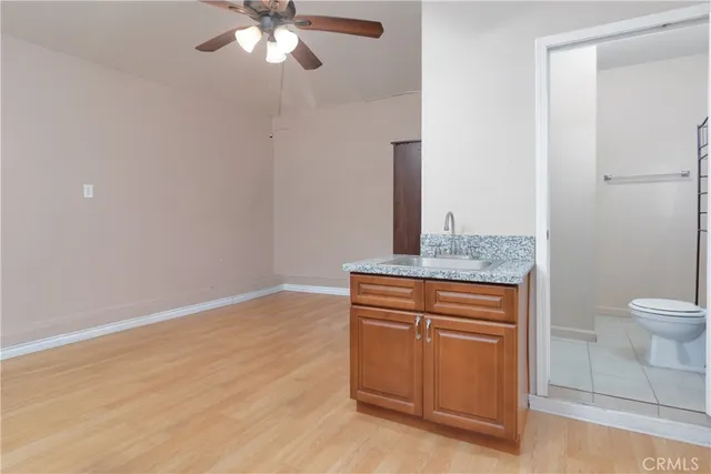a bathroom with a granite countertop sink a toilet and a mirror