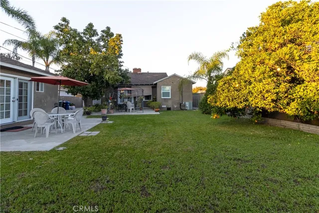 a view of house with backyard and outdoor seating