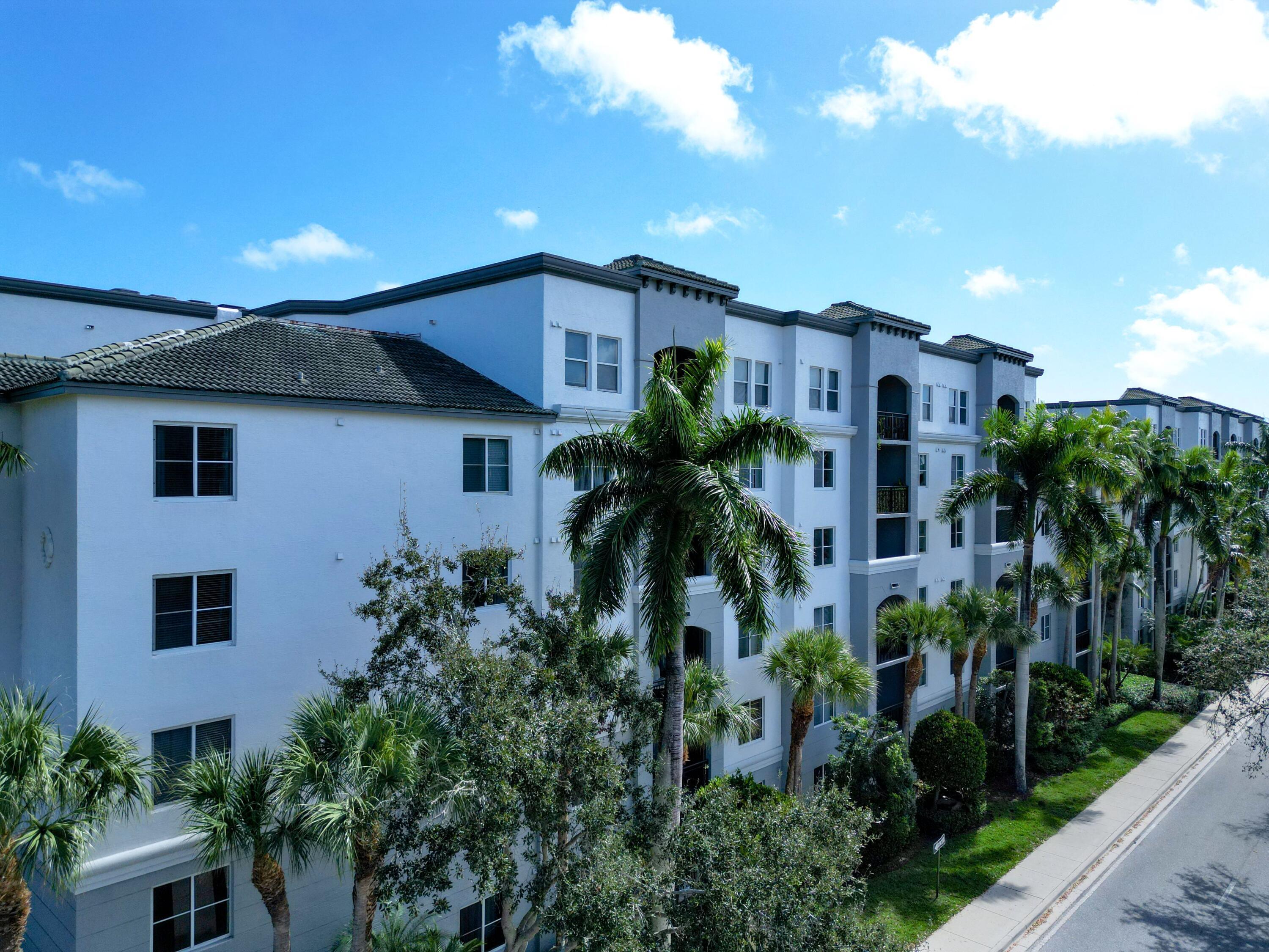 1690 Renaissance Commons Boulevard, Unit 1412 Boynton Beach, FL 33426 - Photo 28 of 49 a front view of a house with plants and trees