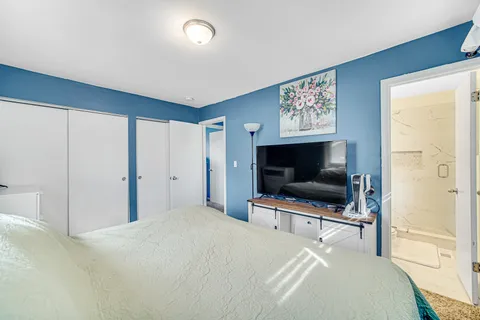 a bedroom with a bed and a flat screen tv