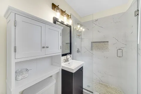 a bathroom with a sink a toilet and shower