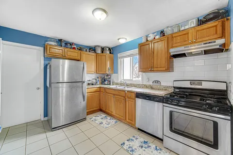 a kitchen with stainless steel appliances granite countertop a refrigerator sink and stove