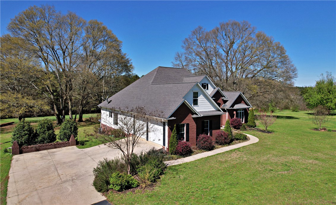 7893 Athens Road Carnesville, GA 30521 - Photo 42 of 50 This charming home features a classic brick and siding exterior, nestled amidst mature trees and lush greenery.