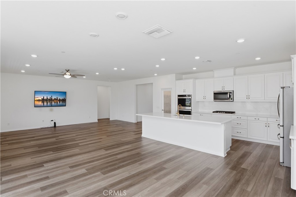 21159 Blue Jeans Court Riverside, CA 92507 - Photo 27 of 63 a large white kitchen with kitchen island a sink a stove and a refrigerator