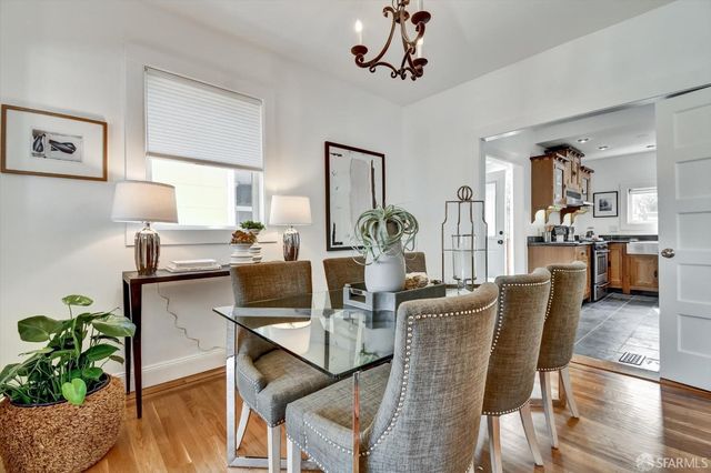 a dining room with furniture potted plants and wooden floor