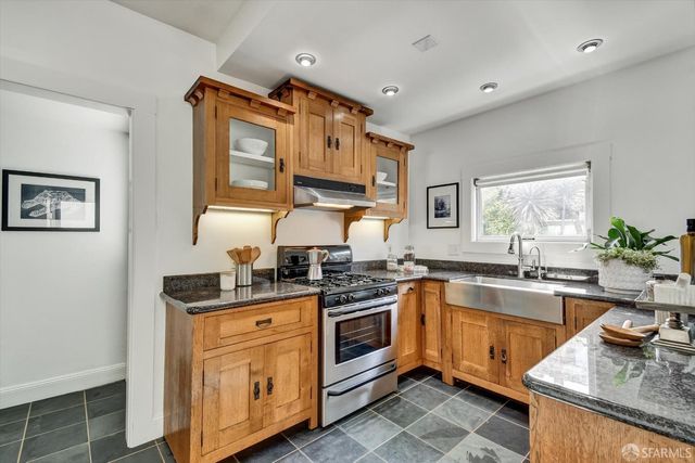 a kitchen with stainless steel appliances granite countertop a sink stove and cabinets