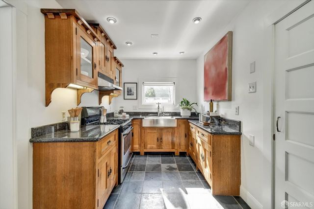 a kitchen with stainless steel appliances granite countertop a sink and stove