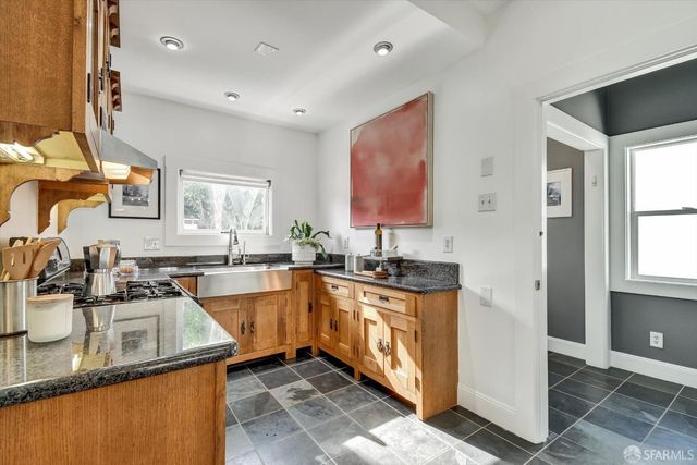 a kitchen with stainless steel appliances granite countertop a sink stove and refrigerator