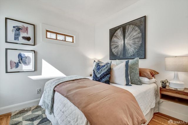 a bedroom with bed and wall painting with wooden floor
