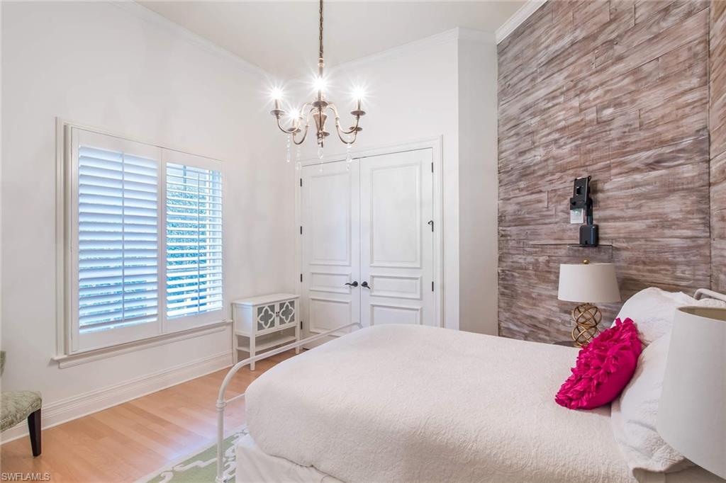 516 Portside Drive Naples, FL 34103 - Photo 20 of 25 a bedroom with a bed and a chandelier