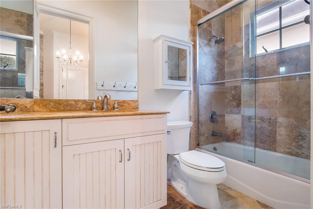 516 Portside Drive Naples, FL 34103 - Photo 22 of 25 a bathroom with a granite countertop sink toilet mirror and shower