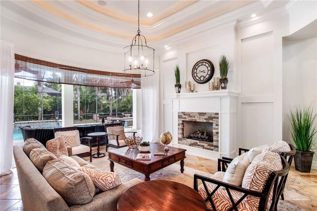 516 Portside Drive Naples, FL 34103 - Photo 4 of 25 a living room with furniture a fireplace and a large window