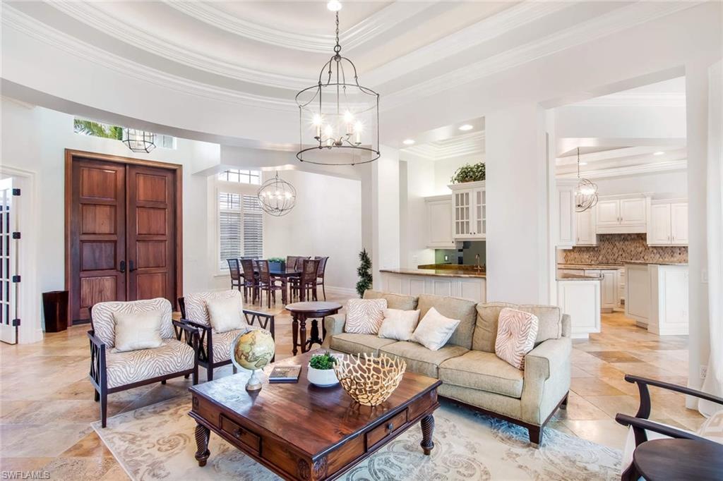 516 Portside Drive Naples, FL 34103 - Photo 5 of 25 a living room with fireplace furniture and a chandelier