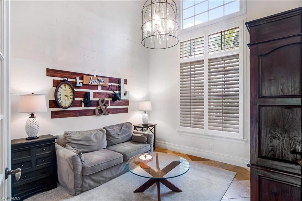 516 Portside Drive Naples, FL 34103 - Photo 7 of 25 a living room with furniture a fireplace and a window