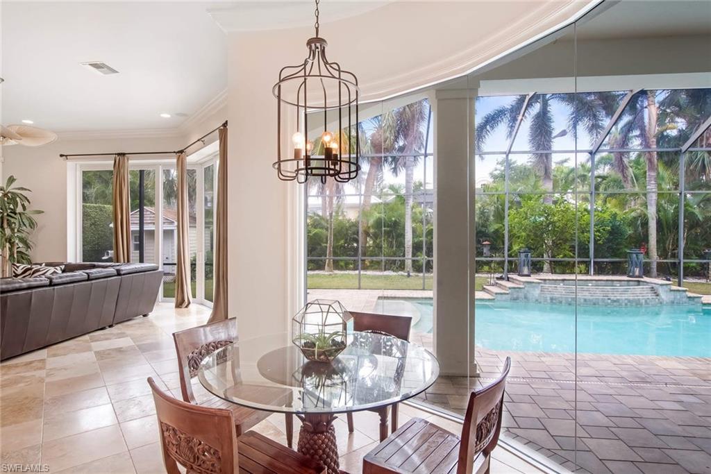 516 Portside Drive Naples, FL 34103 - Photo 10 of 25 a dining room with furniture floor to ceiling windows and wooden floor