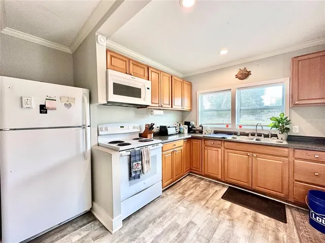 a kitchen with granite countertop appliances a sink and a refrigerator