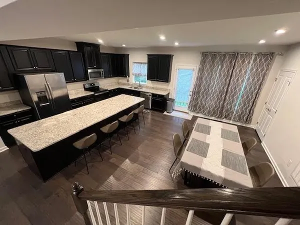 a living room with stainless steel appliances kitchen island granite countertop furniture a rug and a kitchen view