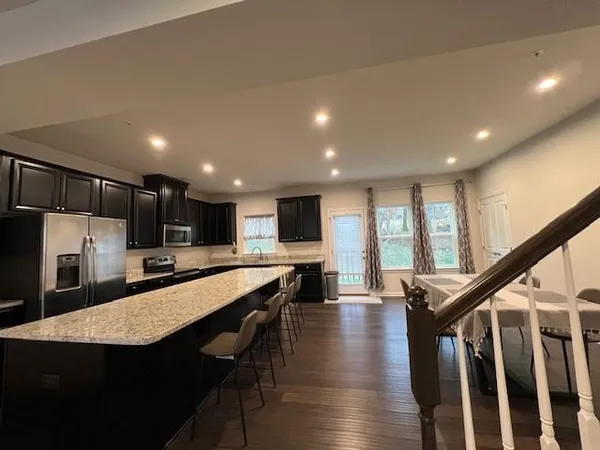 a large kitchen with lots of counter space a sink appliances and a living room