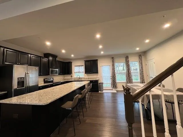 a large kitchen with lots of counter space a sink appliances and a living room