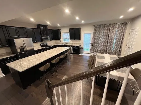 a view of a kitchen with kitchen island a counter and a sink