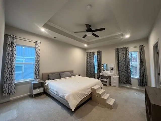 a bedroom with a bed a chandelier and next to a window