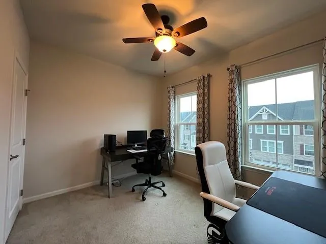 a view of a workspace with furniture and a window