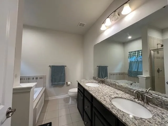 a bathroom with a granite countertop sink a mirror and a toilet