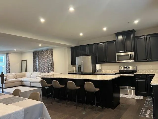 a large kitchen with lots of counter space a sink and chairs