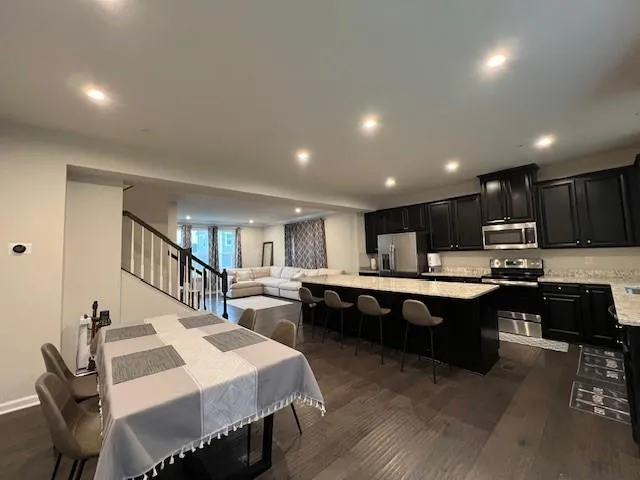 a large kitchen with kitchen island a sink a table and chairs in it