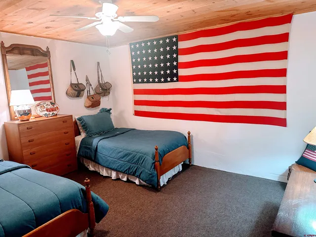 a bedroom with a bed and lamp on the dresser