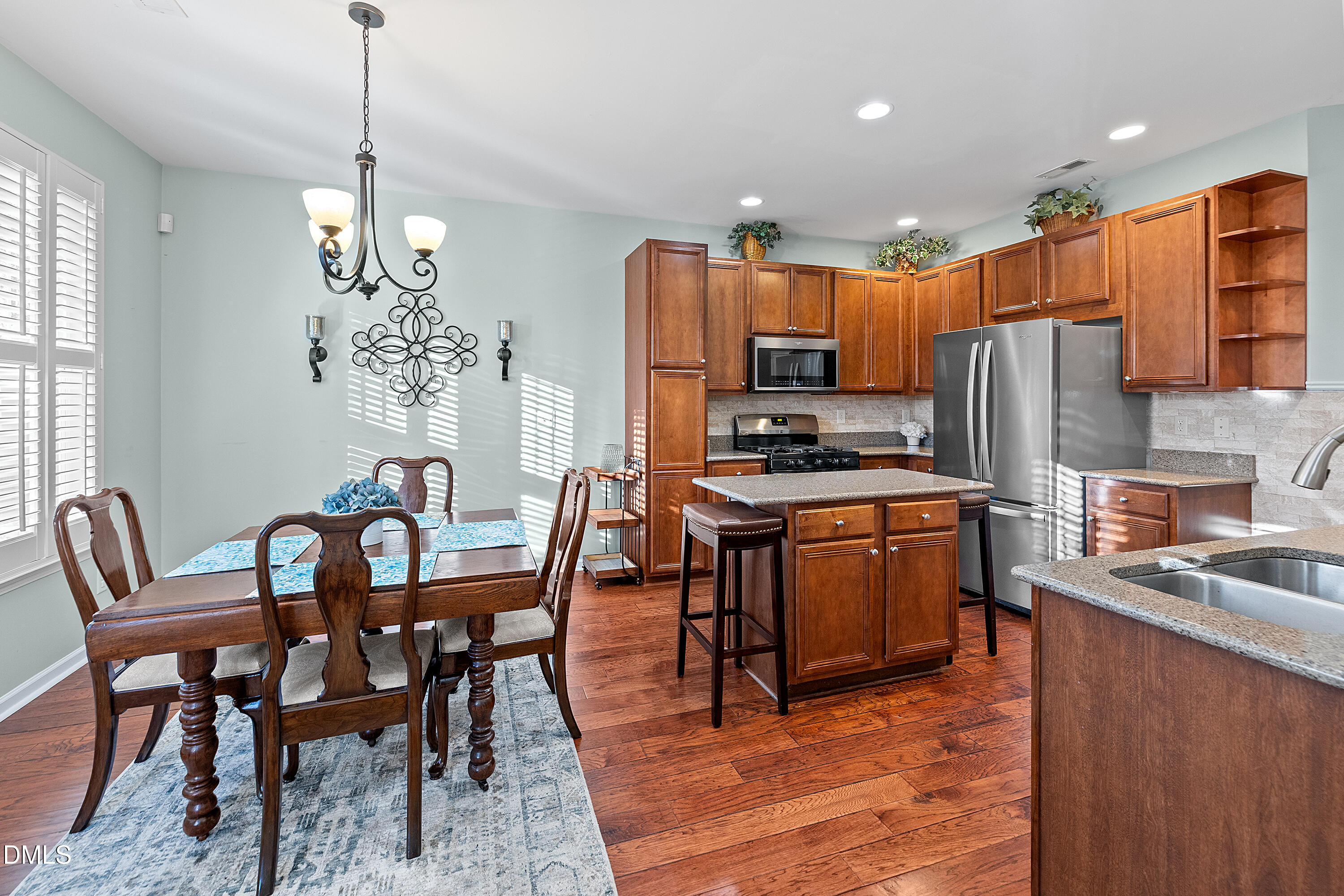 7837 Cape Charles Drive Raleigh, NC 27617 - Photo 14 of 43 a kitchen with stainless steel appliances granite countertop a stove a refrigerator a kitchen island a dining table and chairs