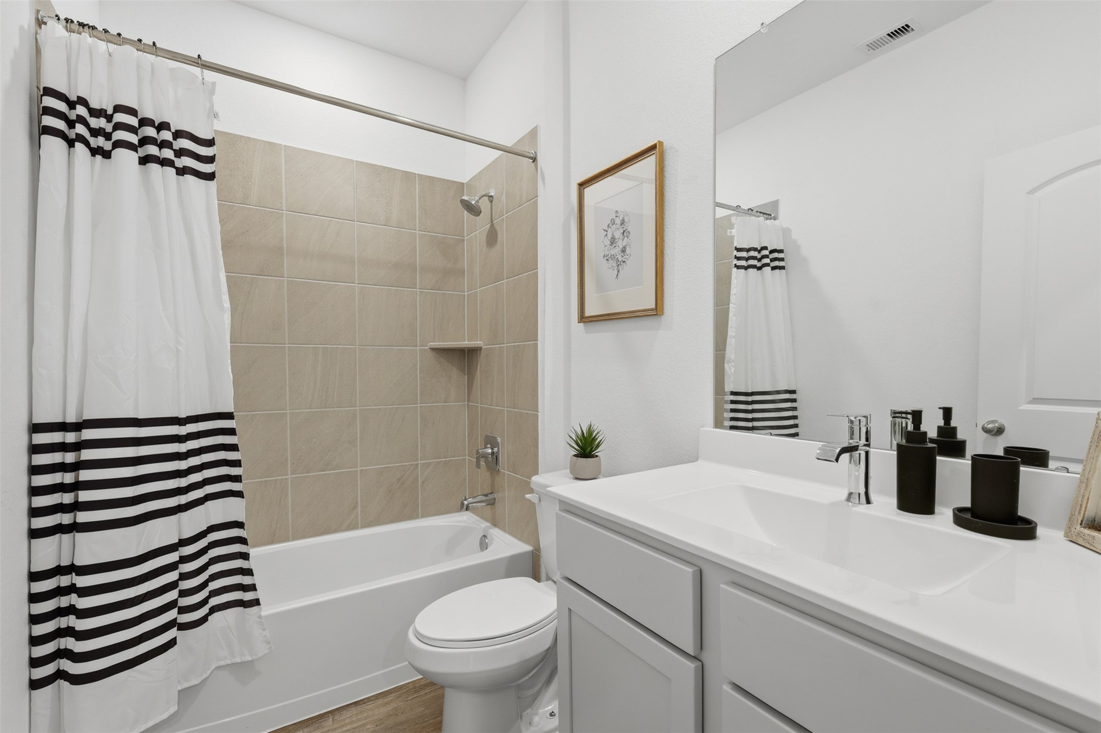 17719 Winfall Drive Crosby, TX 77532 - Photo 33 of 47 This third bathroom features a clean, modern design with a white vanity and sink, large mirror, and neutral tile tub/shower combo.