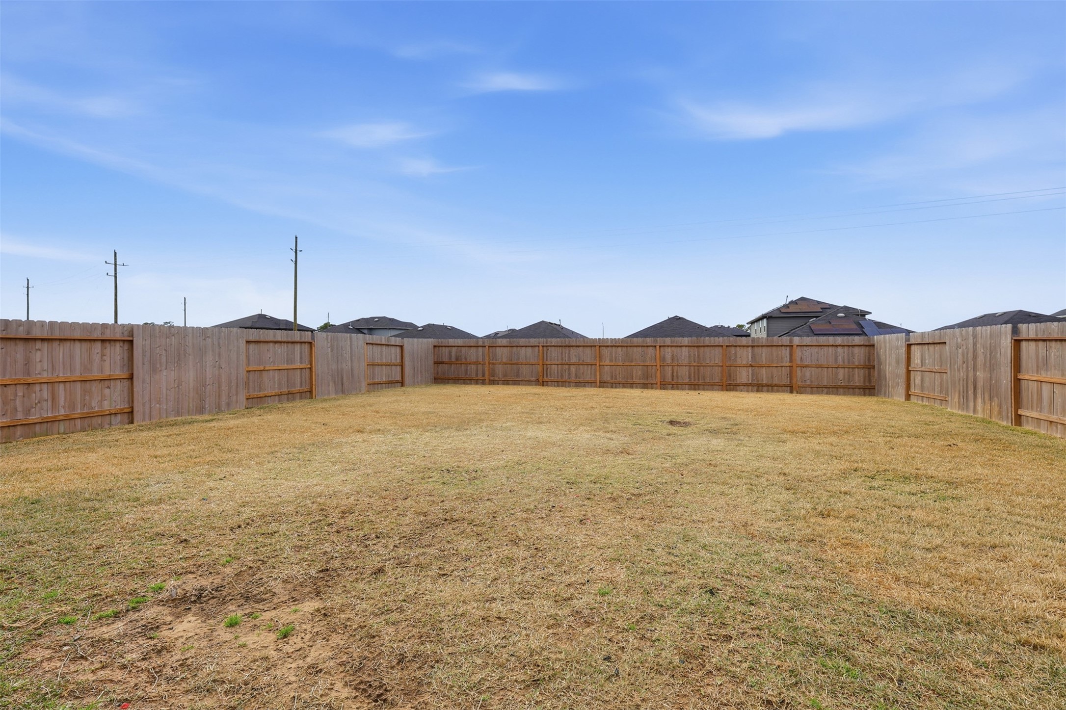 17719 Winfall Drive Crosby, TX 77532 - Photo 39 of 47 Spacious, fenced backyard with a wooden perimeter, offering privacy and ample room for outdoor activities or landscaping.