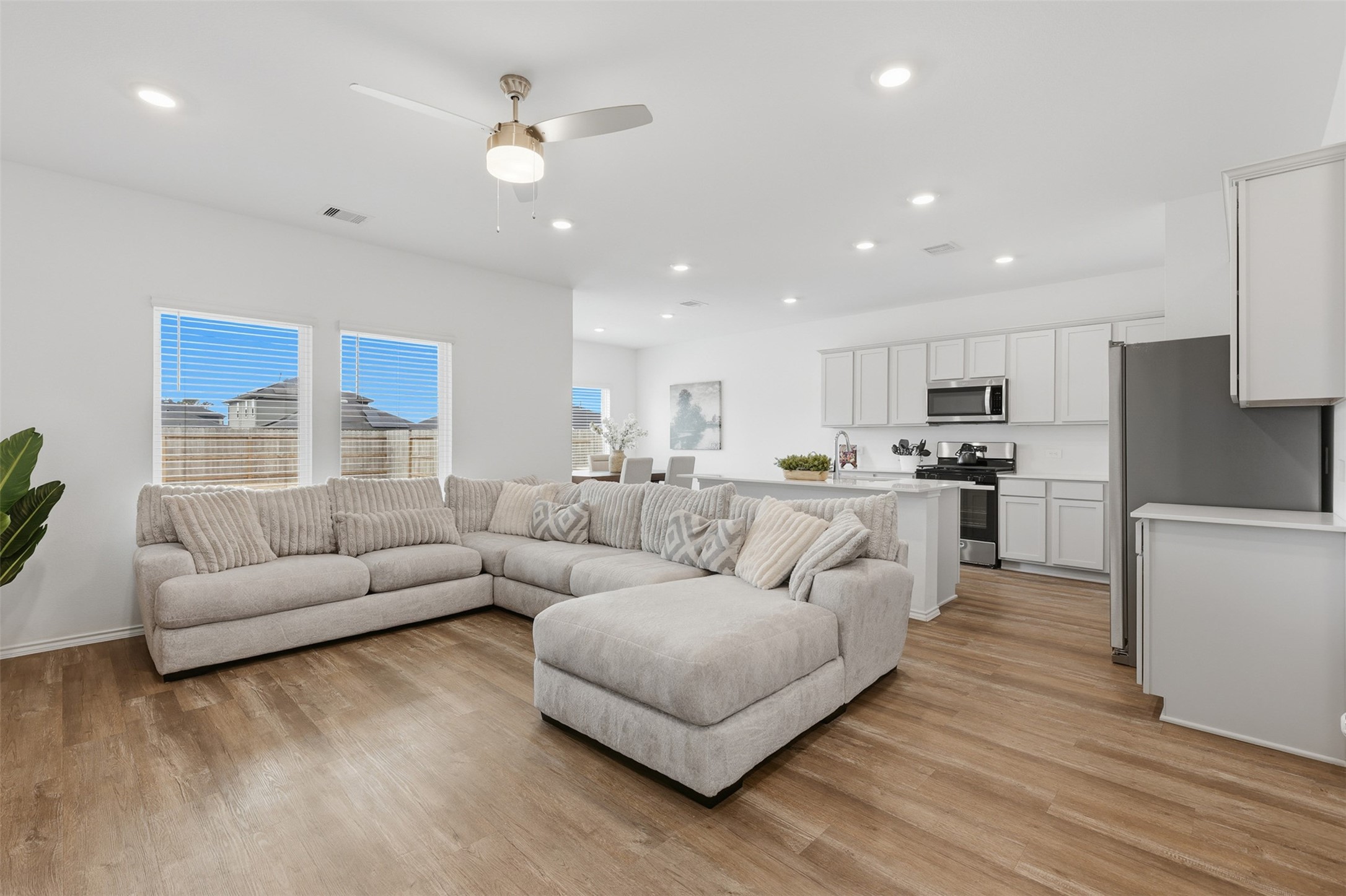 17719 Winfall Drive Crosby, TX 77532 - Photo 7 of 47 This modern open-concept living space features a spacious living room with abundant natural light. The adjacent kitchen is equipped with stainless steel appliances, white cabinetry, and a large island, perfect for entertaining.