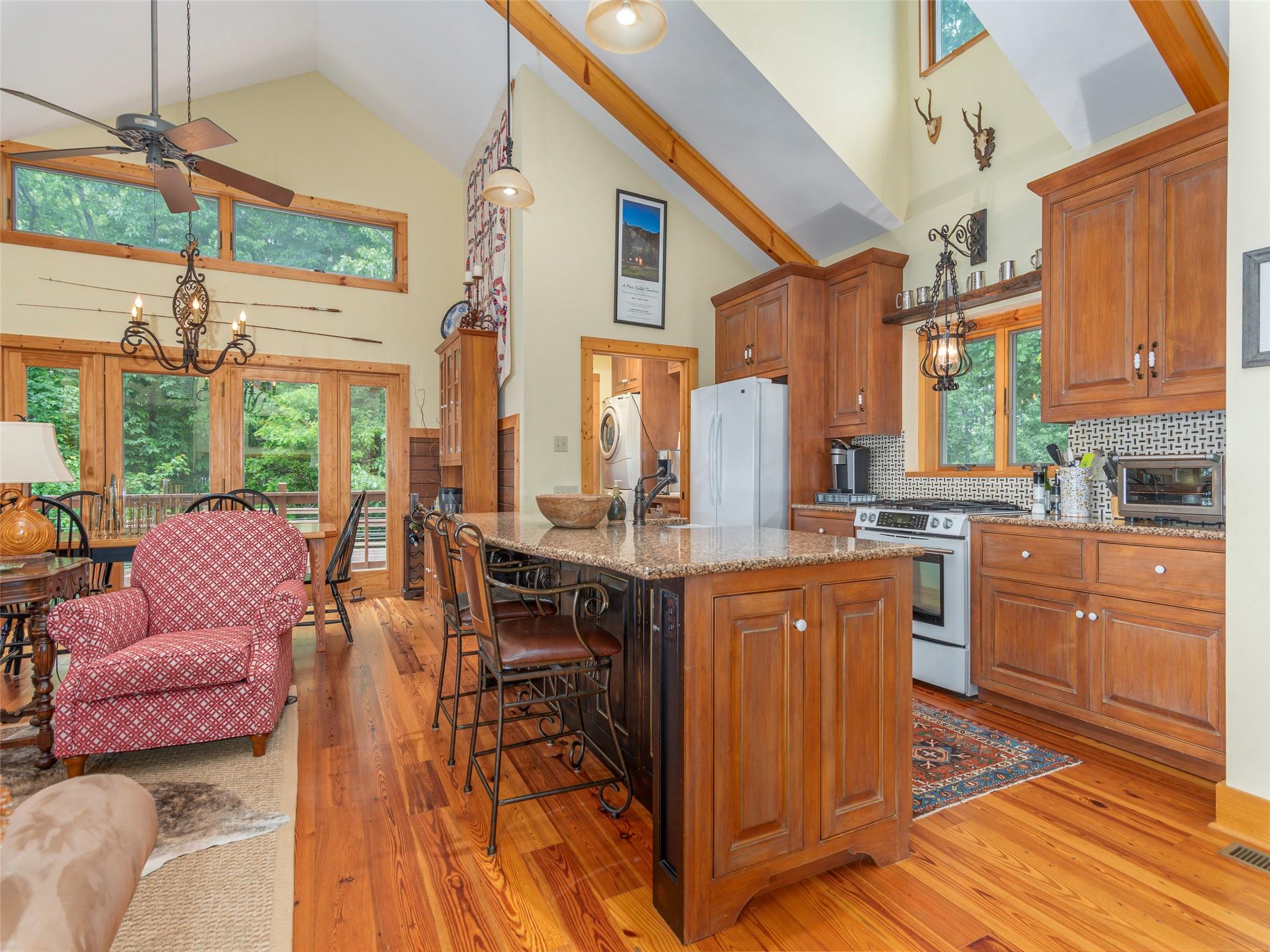 120 Skyridge Drive Clyde, NC 28721 - Photo 13 of 33 a kitchen with stainless steel appliances granite countertop a refrigerator a sink dishwasher a dining table and chairs with wooden floor