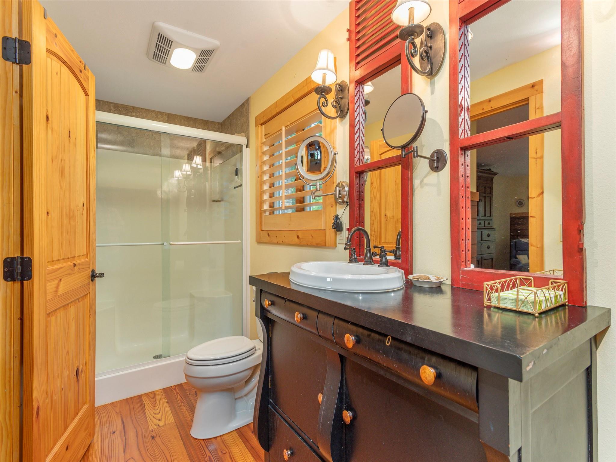 120 Skyridge Drive Clyde, NC 28721 - Photo 19 of 33 a bathroom with a granite countertop sink toilet a mirror and shower