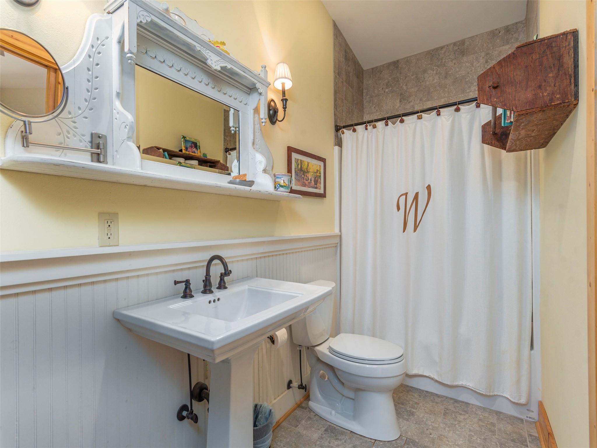 120 Skyridge Drive Clyde, NC 28721 - Photo 22 of 33 a bathroom with a sink a mirror a toilet and vanity