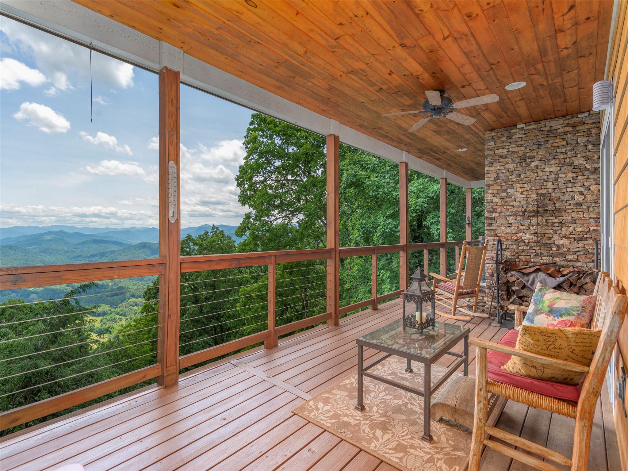 120 Skyridge Drive Clyde, NC 28721 - Photo 4 of 33 a view of a balcony with chairs and wooden floor