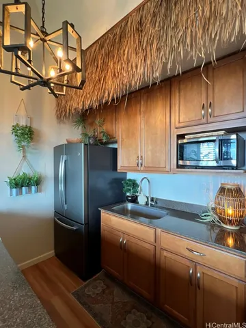 a kitchen with stainless steel appliances granite countertop a refrigerator a stove and a sink